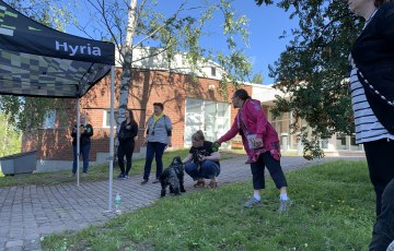Hyrian opinto-ohjaajia, Anne Kivistö ja Kalle-cockeri seisoskelemassa Karankadun kampuksen pihamaalla.