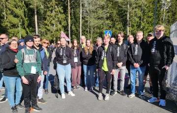 Hyrian Taitaja-joukkue keväisessä auringonpaisteessa Hyria-hupparit päällään valmiina Porissa