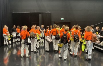 Opiskelijoita työhaalareissa ja reput selässä kuuntelemassa Red Carpet -infoa Hyvinkäällä Villatehtaalla Studio Donnerissa