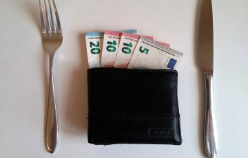 Euron seteleitä lompakossa pöydällä vieressä haarukka ja veitsi
