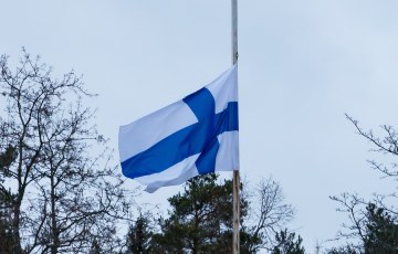 Valokuva suomen lipusta puolitangossa