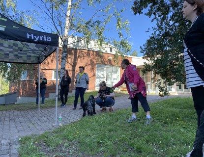 Hyrian opinto-ohjaajia, Anne Kivistö ja Kalle-cockeri seisoskelemassa Karankadun kampuksen pihamaalla.