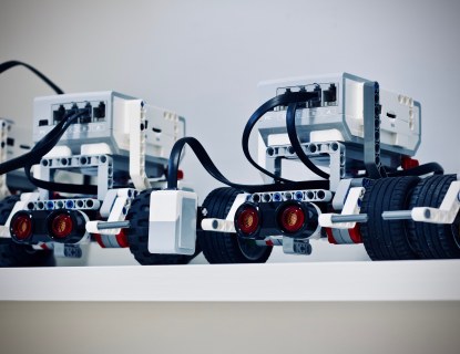 Nelipyöräisiä pieniä robottimönkijöitä rivissä.