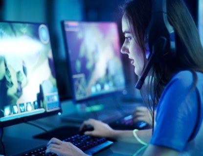 Nuori nainen pelaa counter-strikea tietokoneella