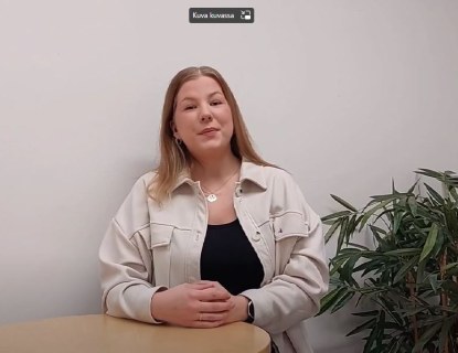 Nainen seisoo pöydän takana.