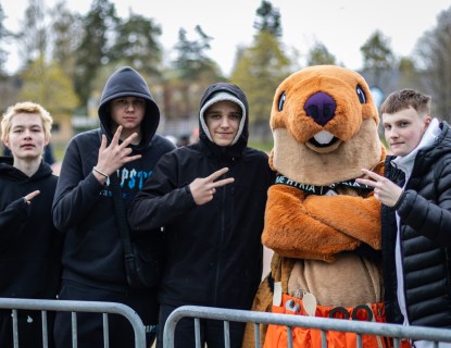Opiskelijoita poseeraamassa Hyrian Heimo-maskotin kanssa